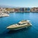 A luxury yacht in the water near a vibrant, colorful harbor lined with historic buildings in Chania, Greece